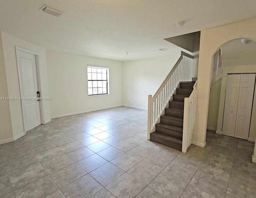 an empty room with staircase and white walls