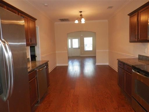 a kitchen with stainless steel appliances wooden floors and wooden cabinets