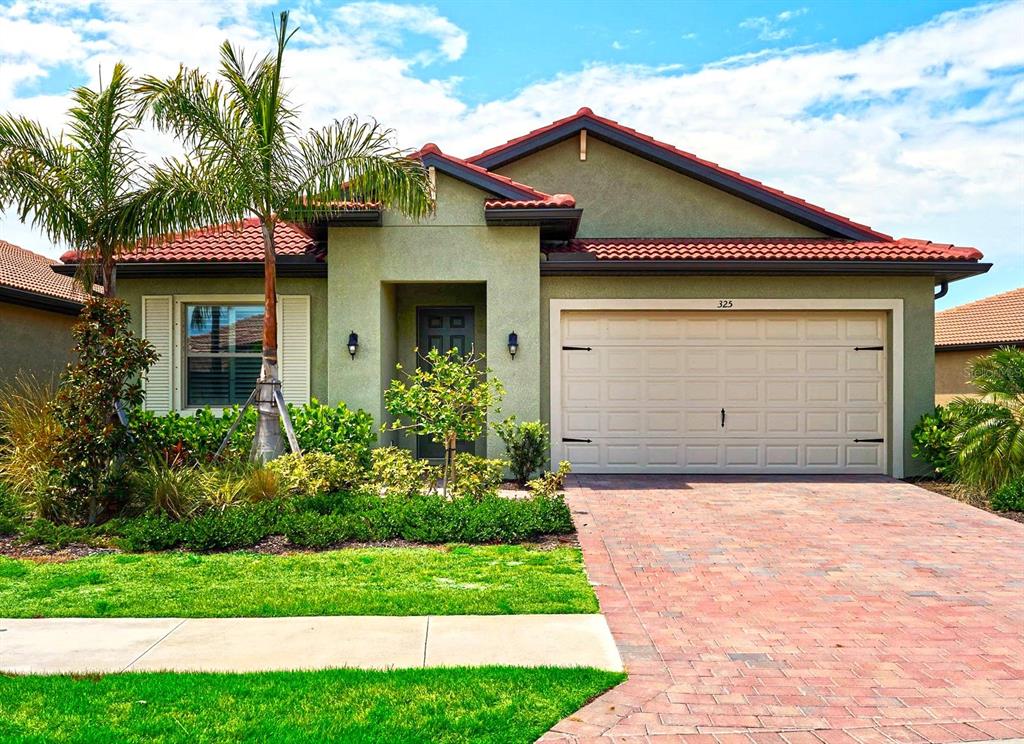 a front view of a house with a yard and garage