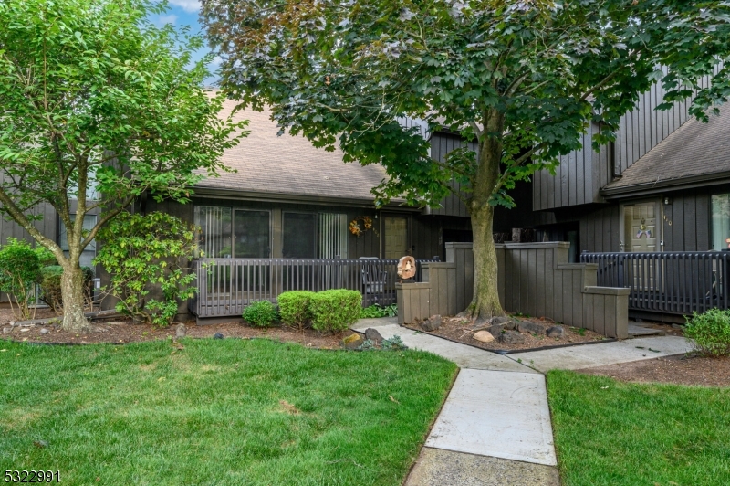 a view of a backyard with table and chairs potted plants and large tree