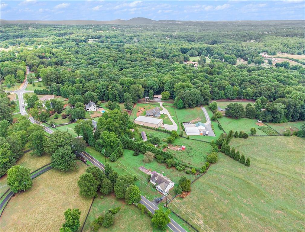 an aerial view of residential houses with outdoor space and trees