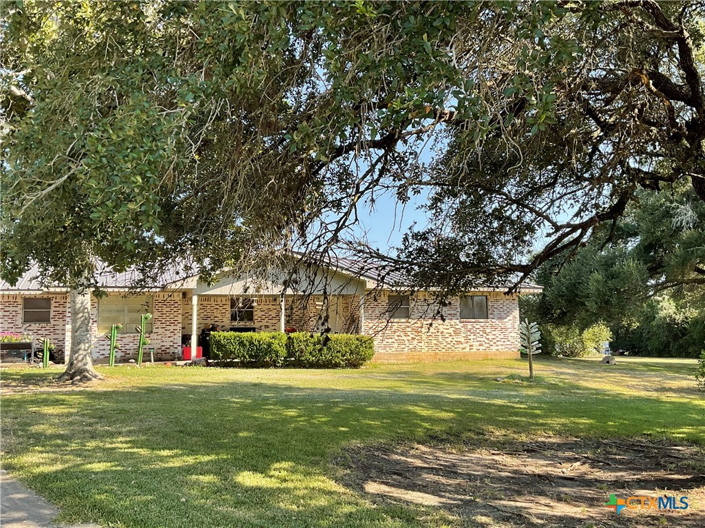 a front view of a house with a garden and trees