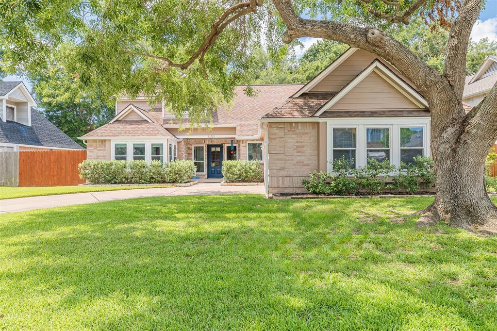 Charming 1.5-story home with a welcoming facade, featuring a spacious lawn, mature shade tree, and a cozy front entrance. The exterior combines brickwork with siding accents under gabled roofs, offering a picturesque suburban appeal.