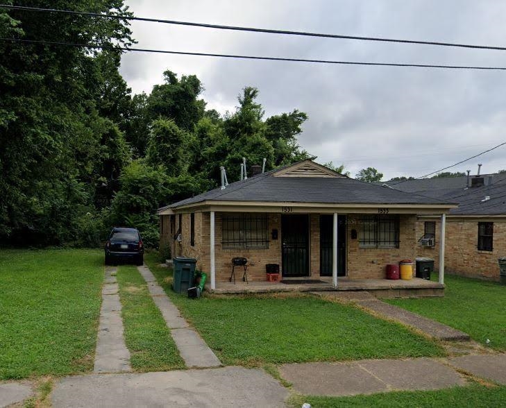 Bungalow featuring covered porch and a front lawn