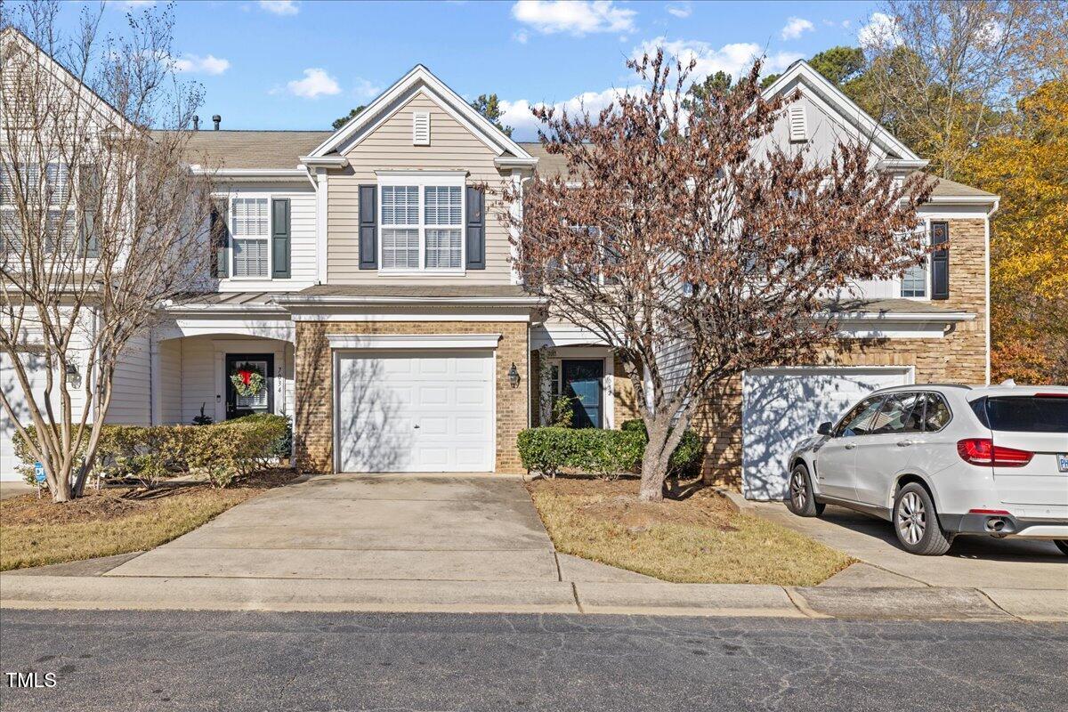 a view of a house with a yard and parking space