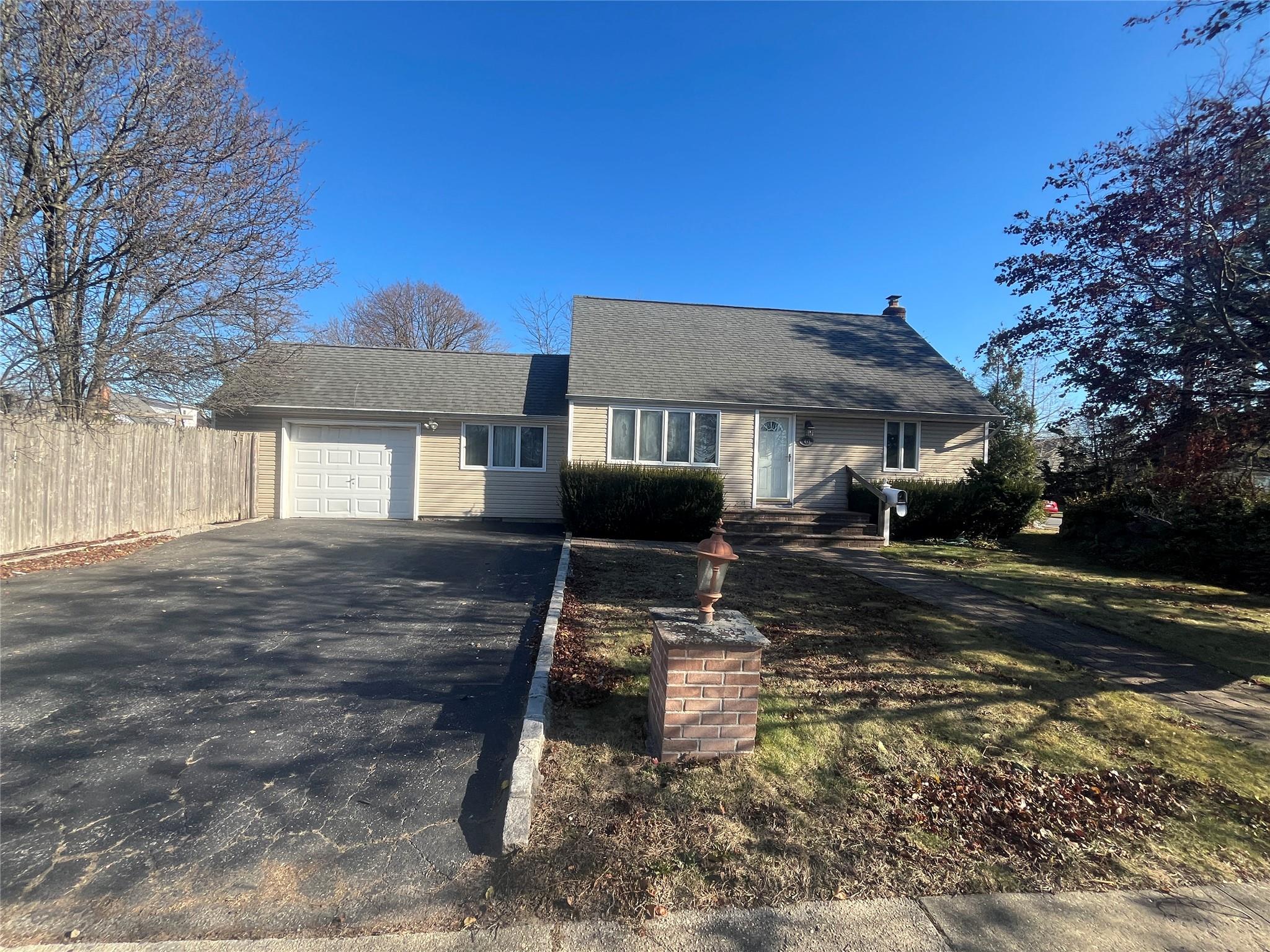 Single story home with a garage and a front yard