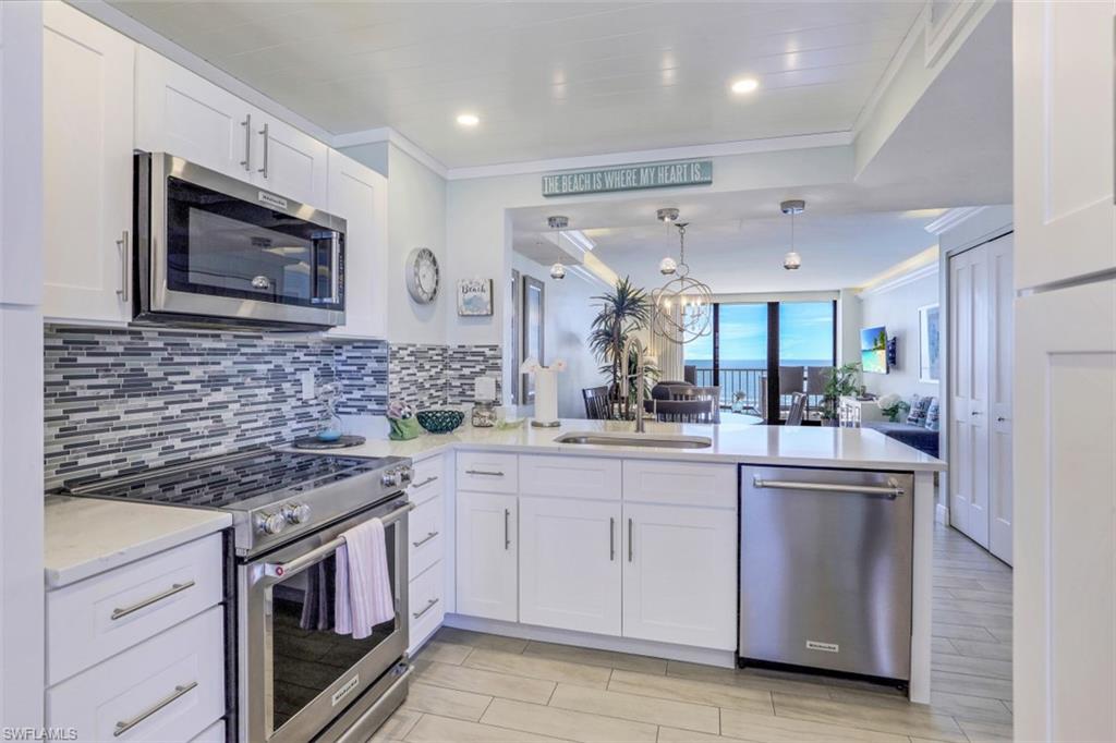 a kitchen with stainless steel appliances granite countertop a stove a sink and a microwave