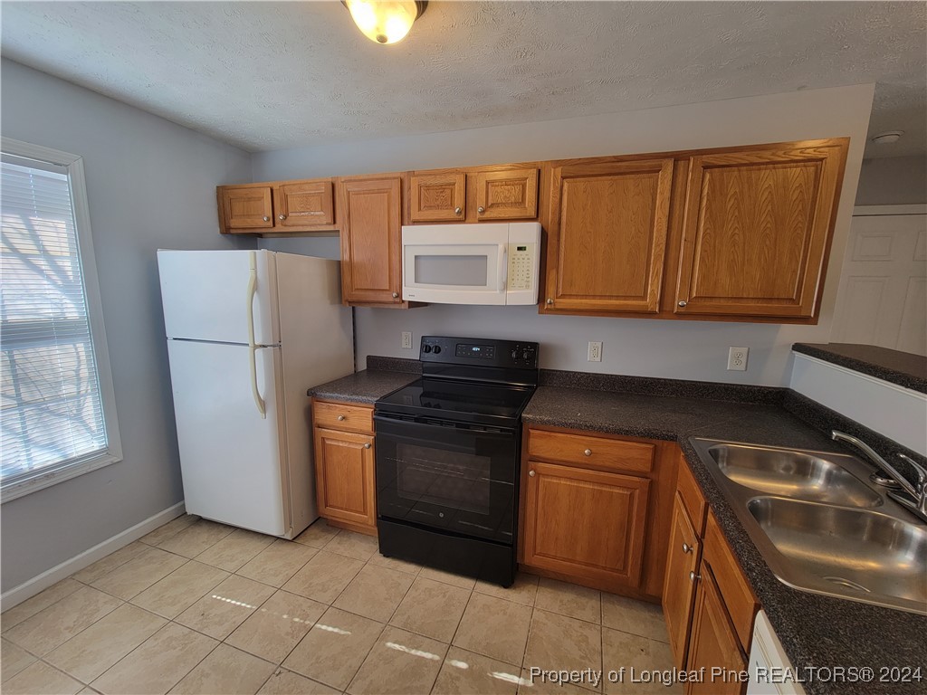 a kitchen with stainless steel appliances granite countertop a stove a refrigerator and a sink