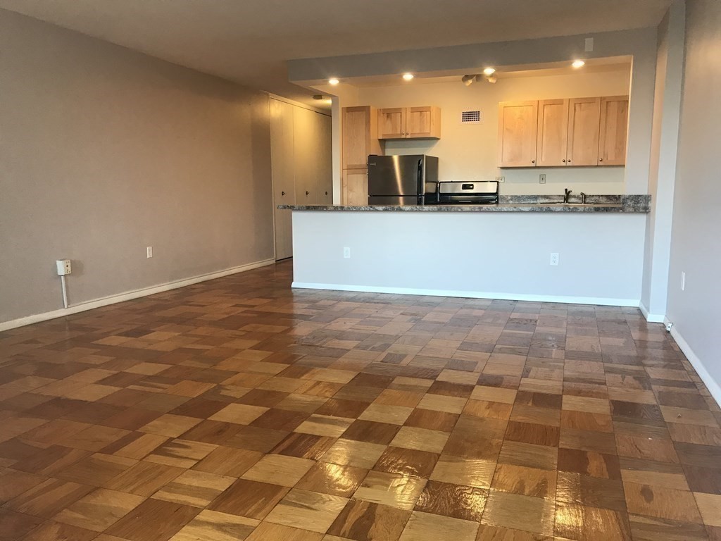 a kitchen with granite countertop a sink a stove top oven and cabinetry