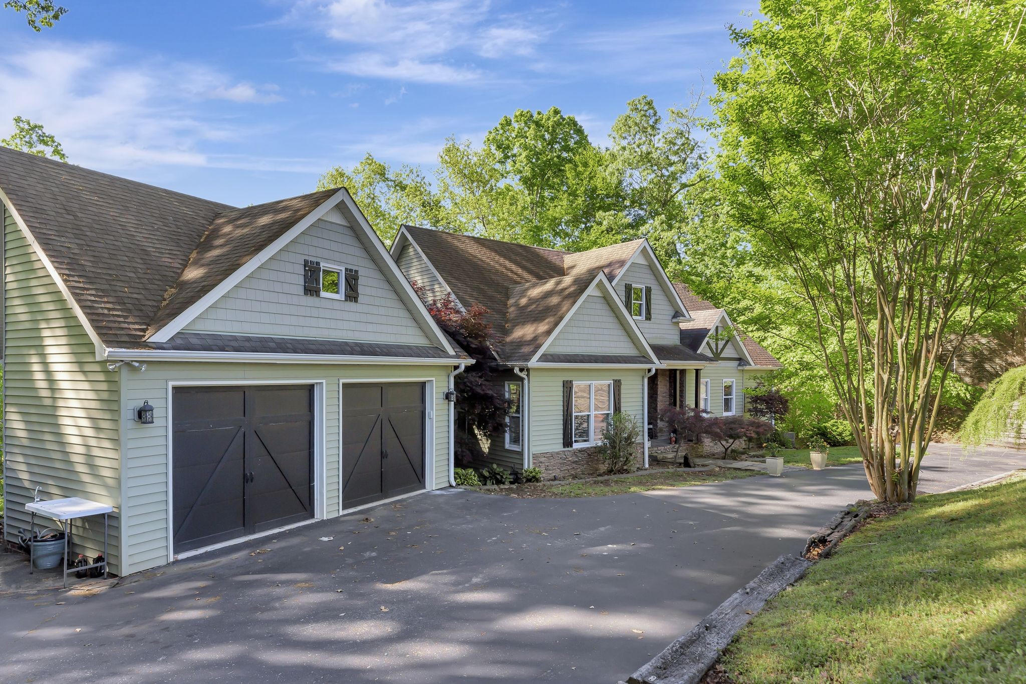 a front view of a house with a garden and trees