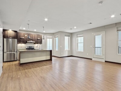 a large space with stainless steel appliances kitchen island wooden cabinets and a window