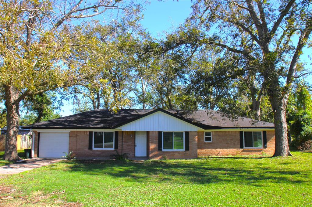 a front view of a house with a yard and trees