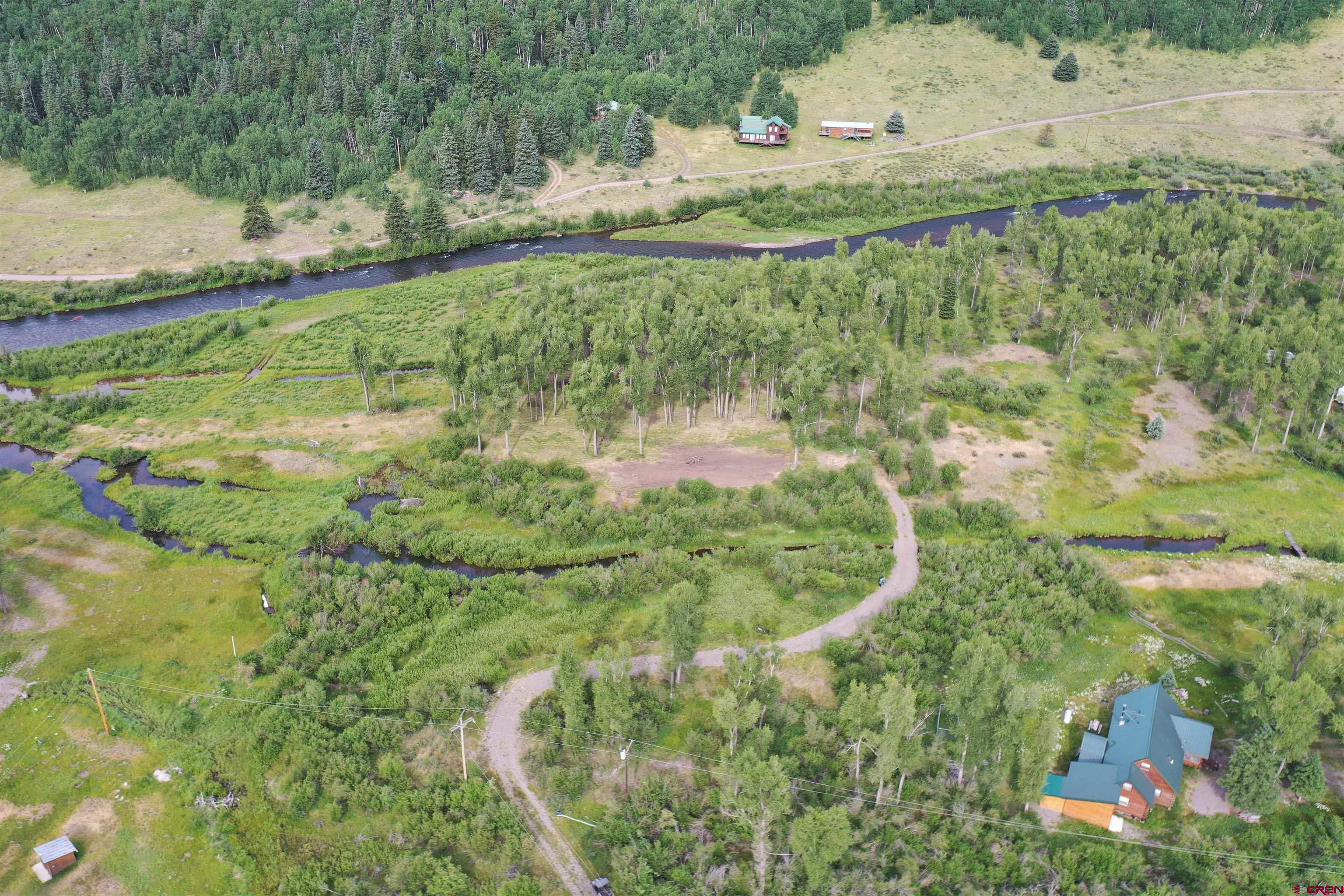 a view of a water pond with green yard