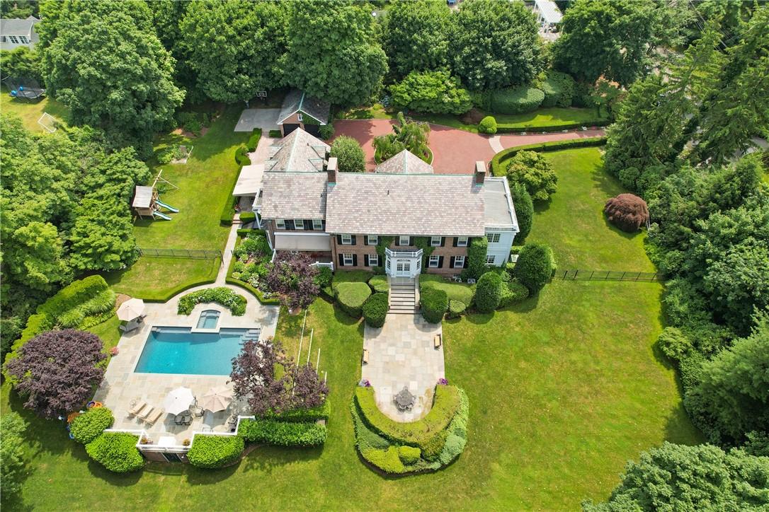 a aerial view of a house with swimming pool and large trees