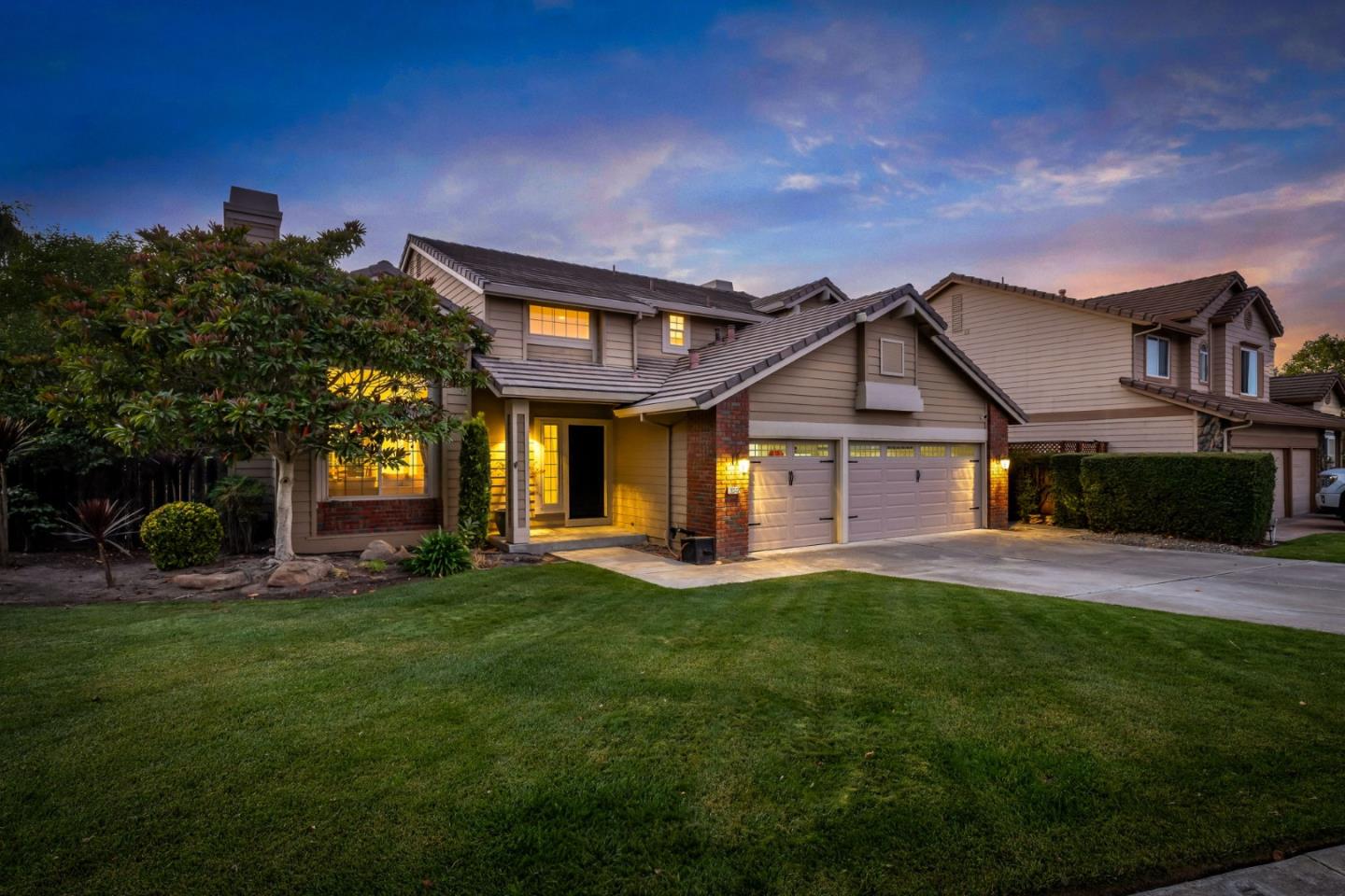 a view of a house with a big yard and large tree