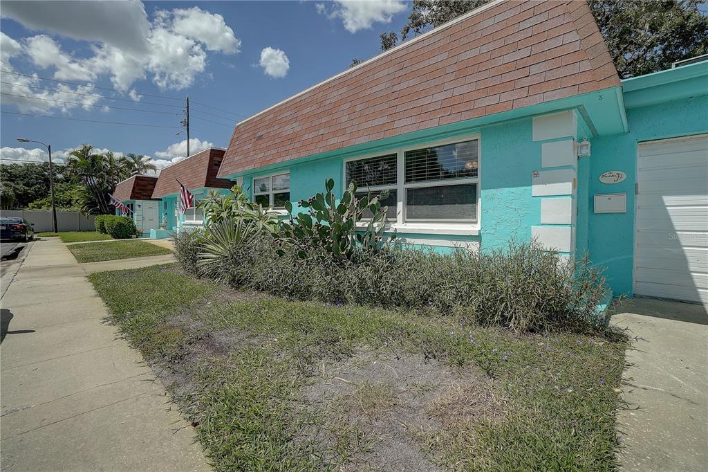 a view of a house with brick walls and a yard with plants