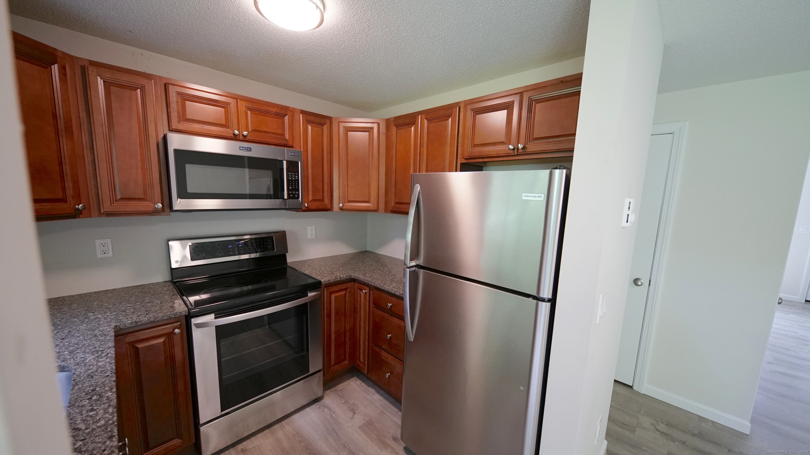 a kitchen with stainless steel appliances granite countertop a refrigerator microwave and sink