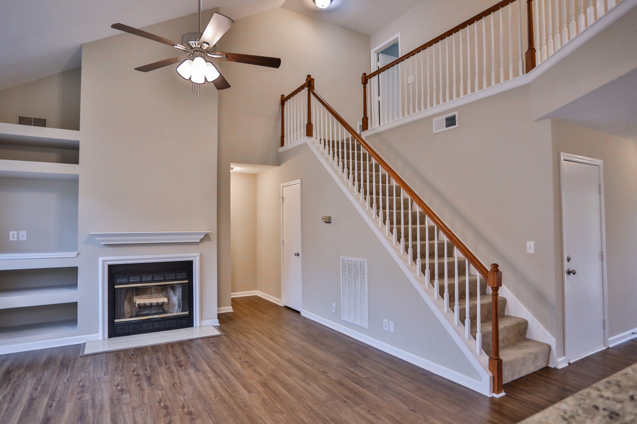 a view of staircase with wooden floor and a fireplace