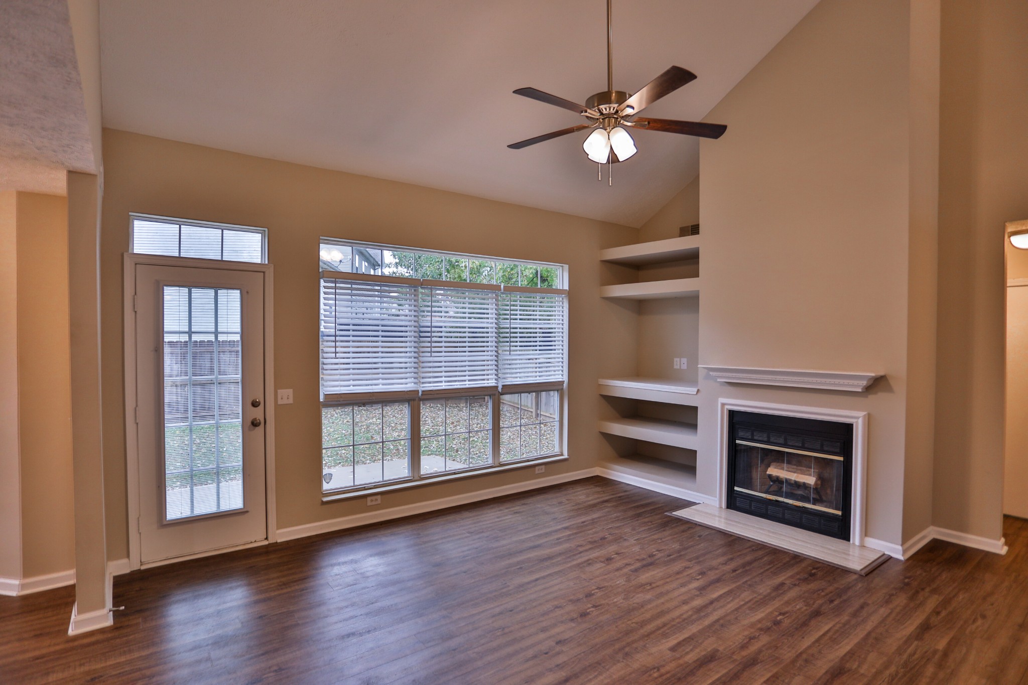 a view of an empty room with a fireplace and a window