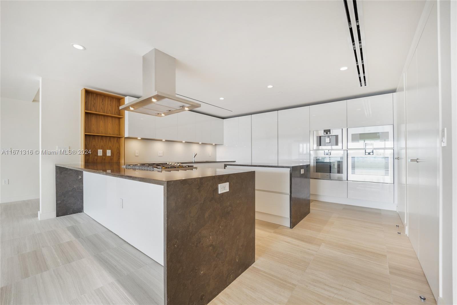 a kitchen with kitchen island a counter top space cabinets and stainless steel appliances