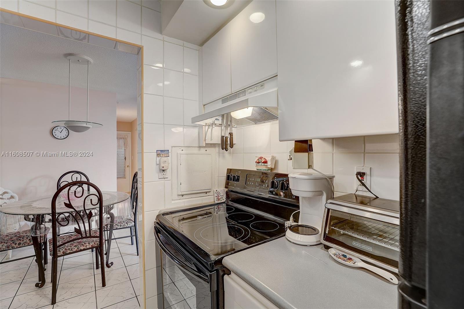 a kitchen with a stove a refrigerator and furniture