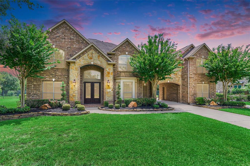 Welcome to 21207 Fairhaven Creek Drive in Lakes of Fairhaven.  Porte-cochere stone and brick elevation with no back neighbors