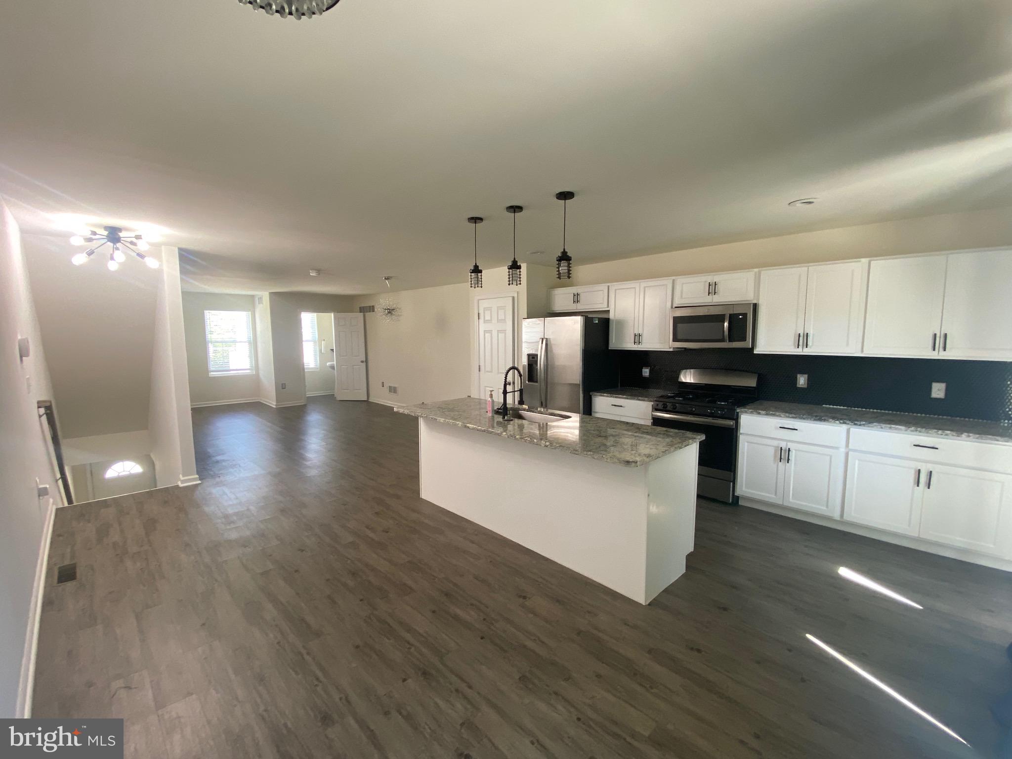 a kitchen with stainless steel appliances a refrigerator sink and white cabinets