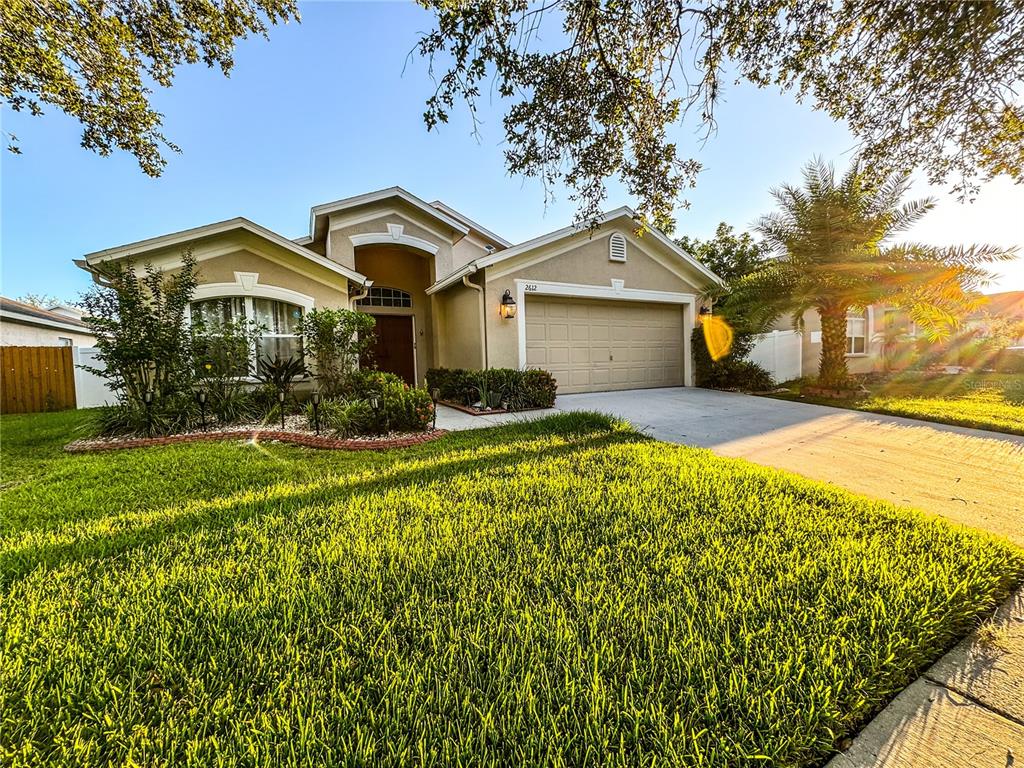 a front view of a house with a yard and trees