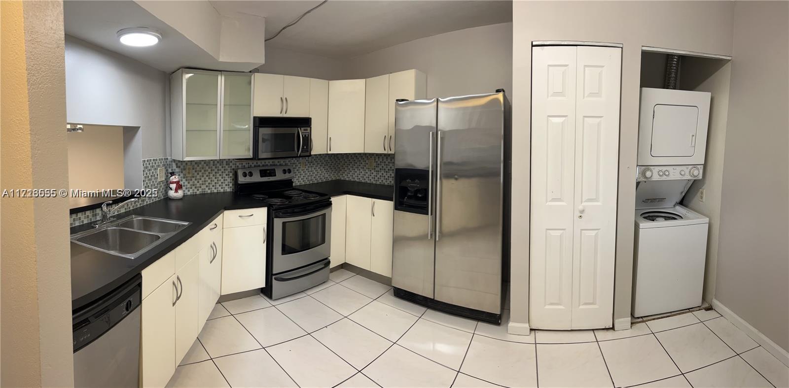 a kitchen with a refrigerator sink and cabinets