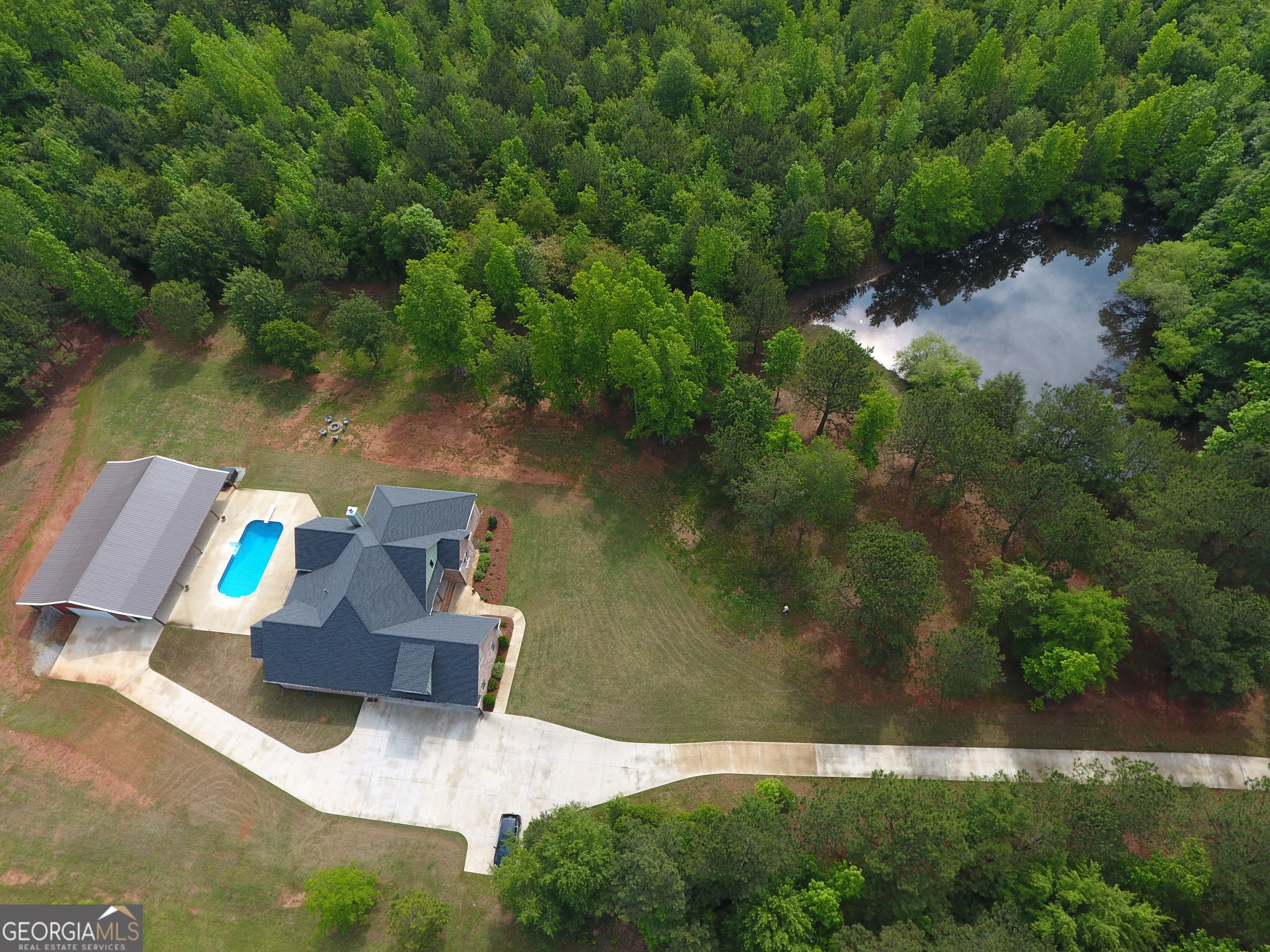 an aerial view of a house with a yard and lake view