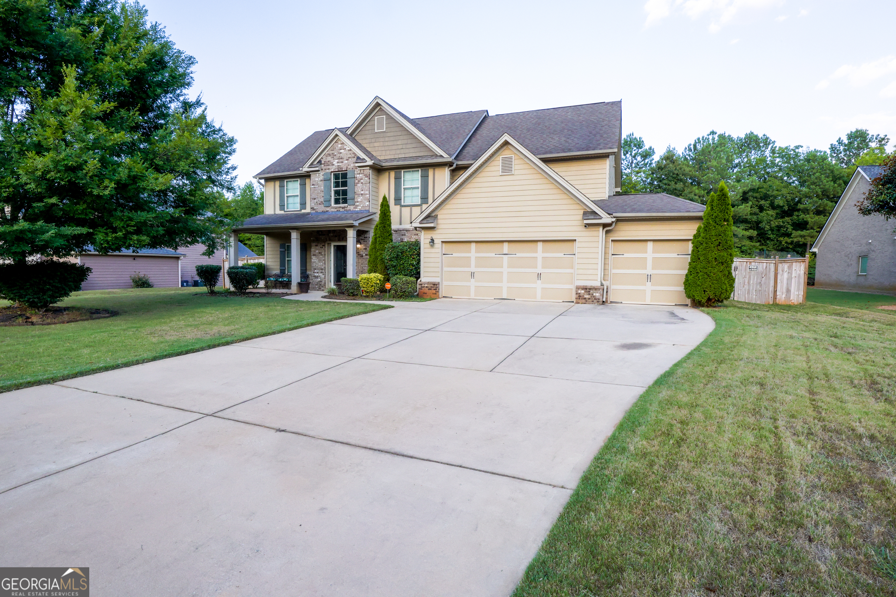 a view of a big house with a big yard and large trees