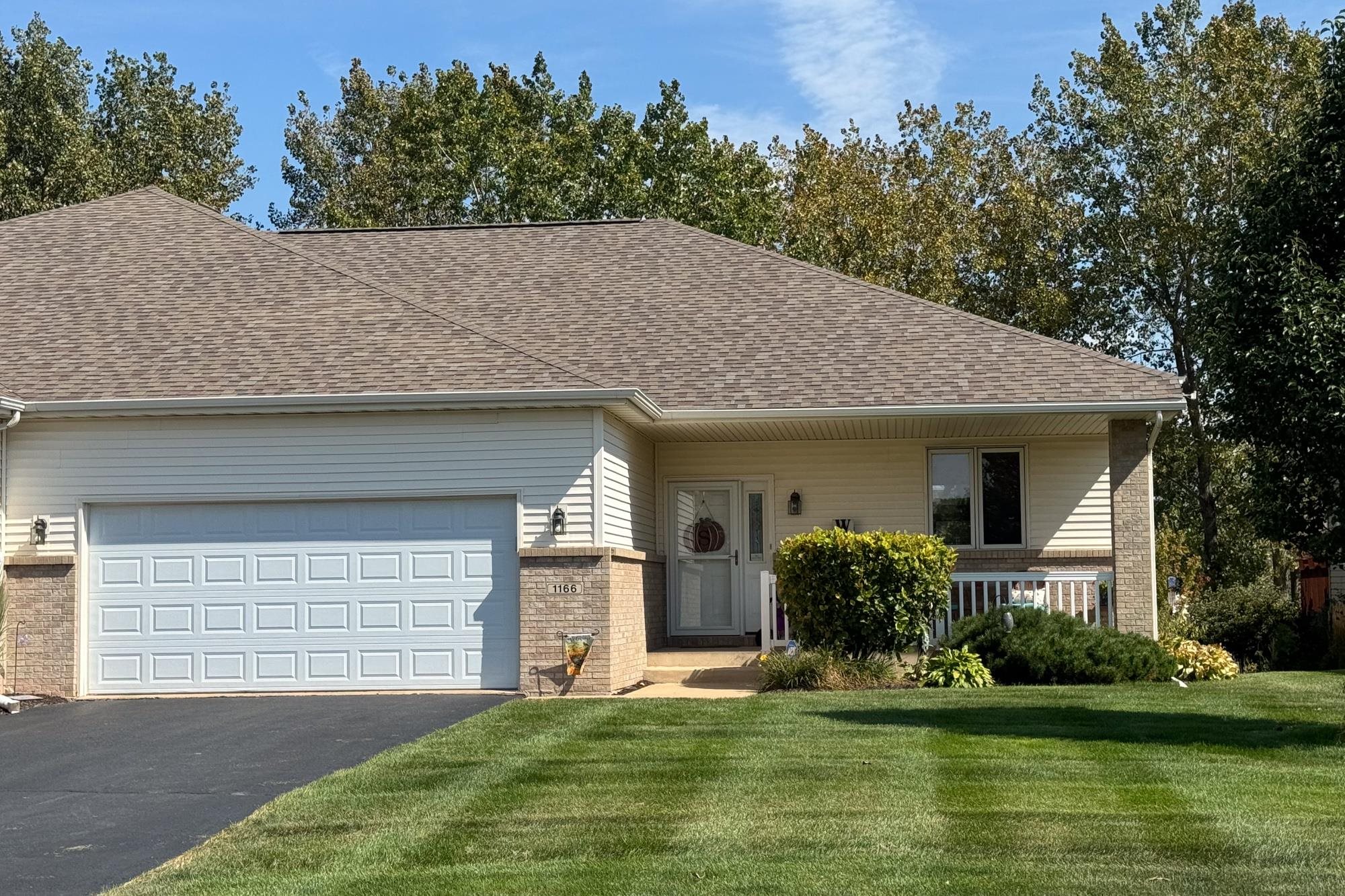 a front view of a house with a yard garage and outdoor seating