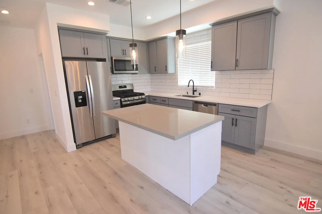 a kitchen with a sink a refrigerator a microwave and cabinets