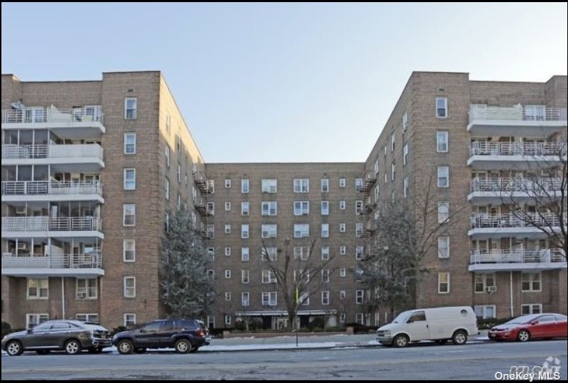 a front view of a building with lot of cars parked