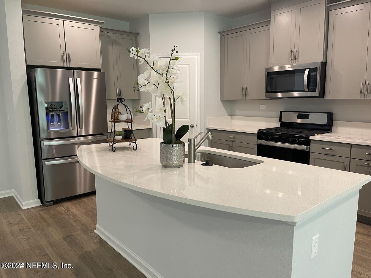 a kitchen with stainless steel appliances a refrigerator sink and microwave