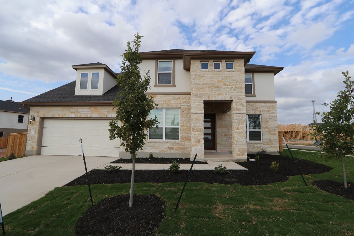 a front view of a house with a garden