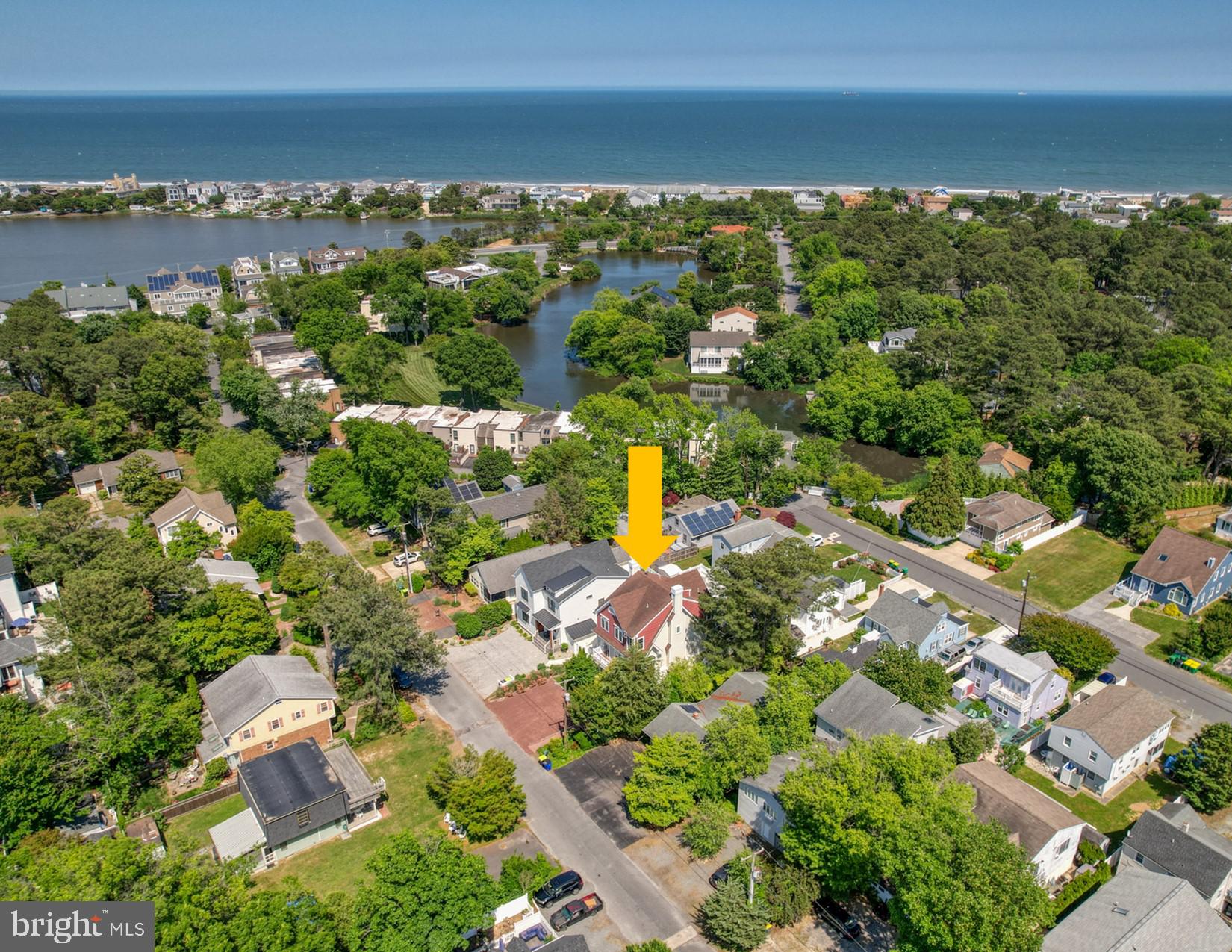 an aerial view of residential houses with outdoor space and lake view