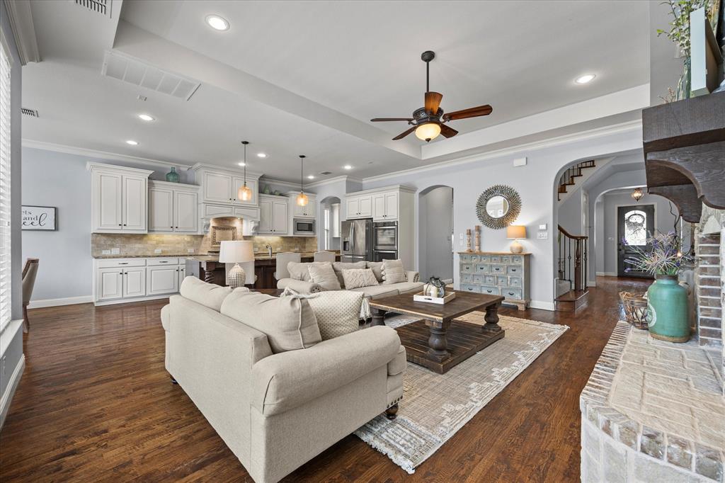 a living room with furniture kitchen view and a chandelier