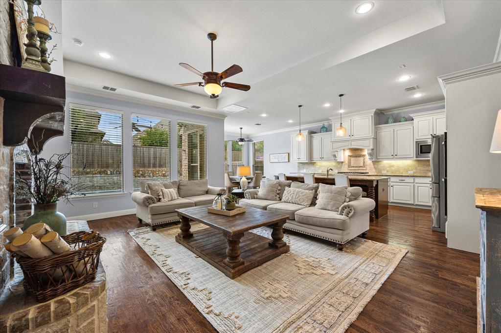 a living room with furniture kitchen view and a wooden floor