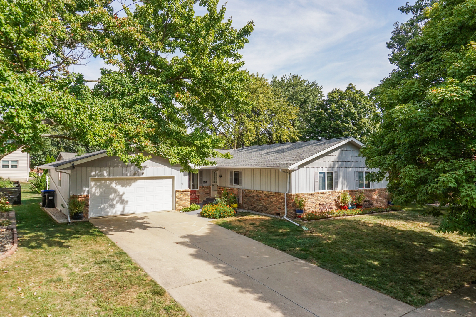 a front view of house with yard and trees around