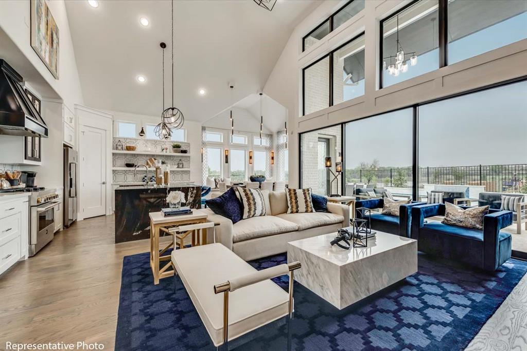 a living room with furniture kitchen view and a large window