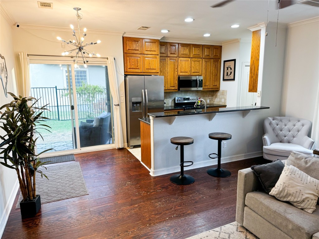 a living room with furniture kitchen view and large windows