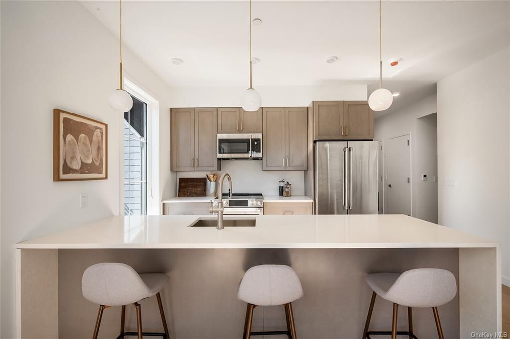 a kitchen with stainless steel appliances kitchen island a table and chairs in it