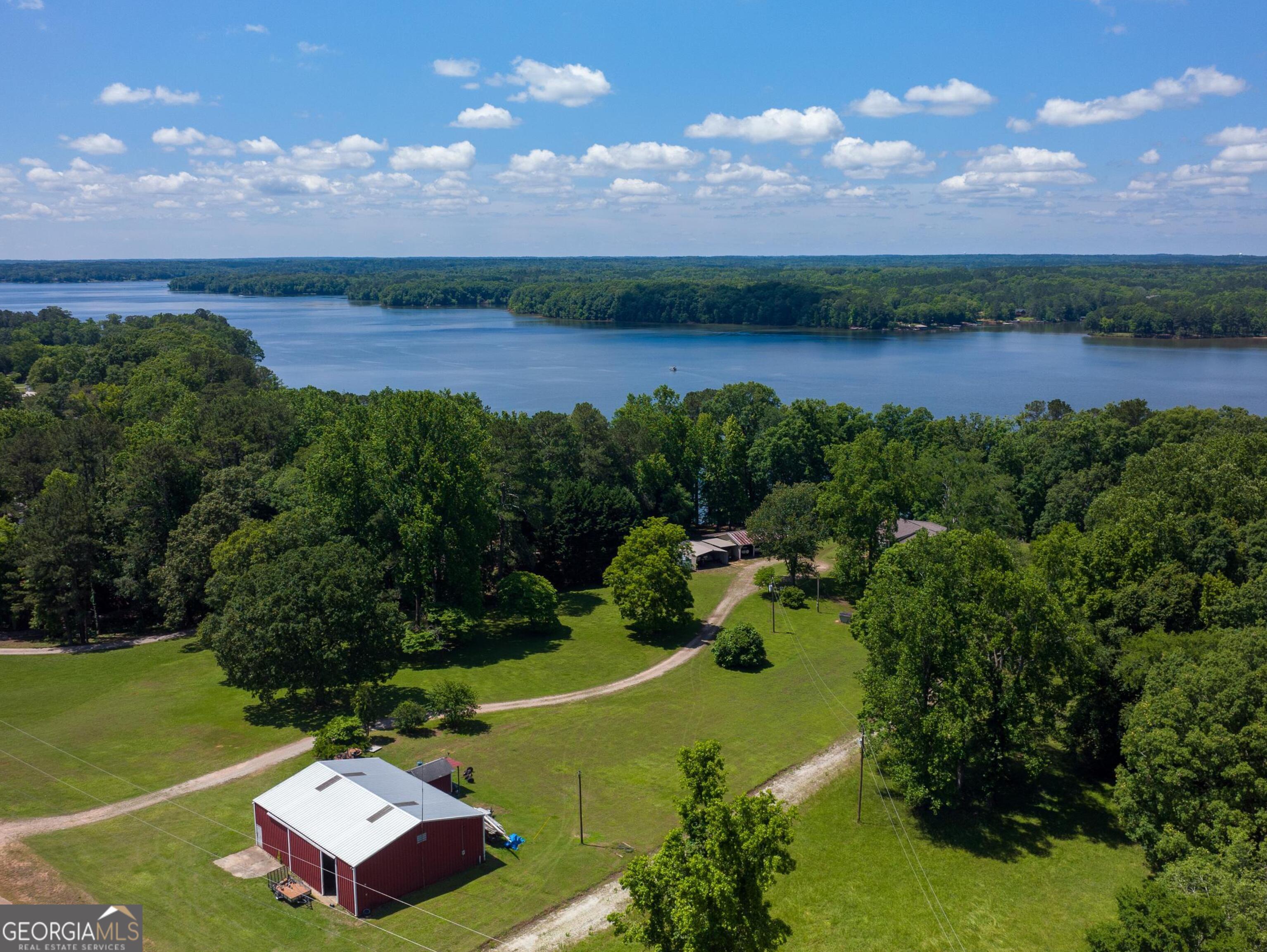 an aerial view of a houses with a garden and lake view