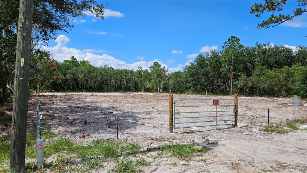 a view of a yard with wooden fence