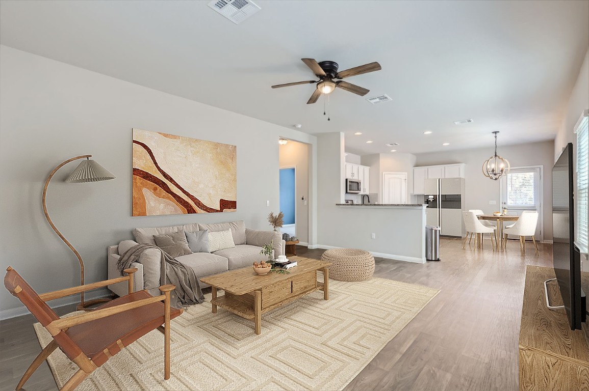 a living room with furniture and a wooden floor