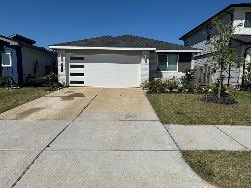 a front view of a house with a yard and a garage