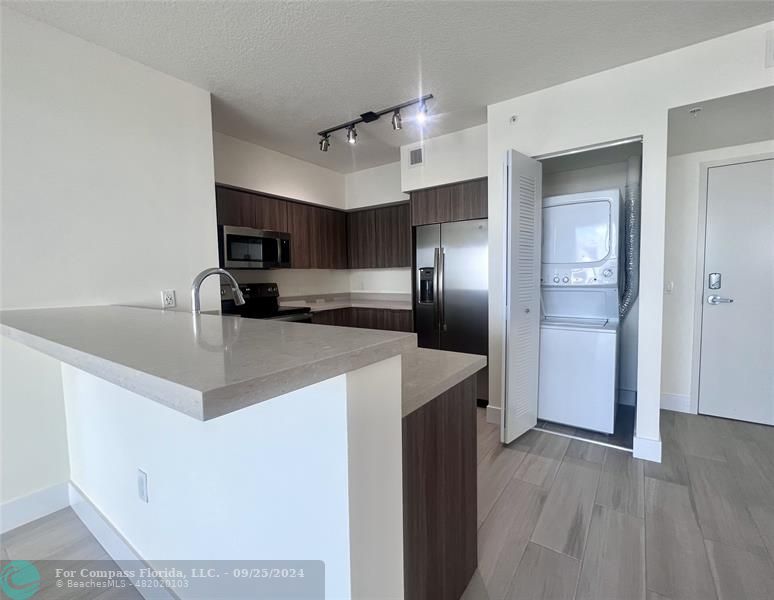 a kitchen with kitchen island a counter top space cabinets and stainless steel appliances