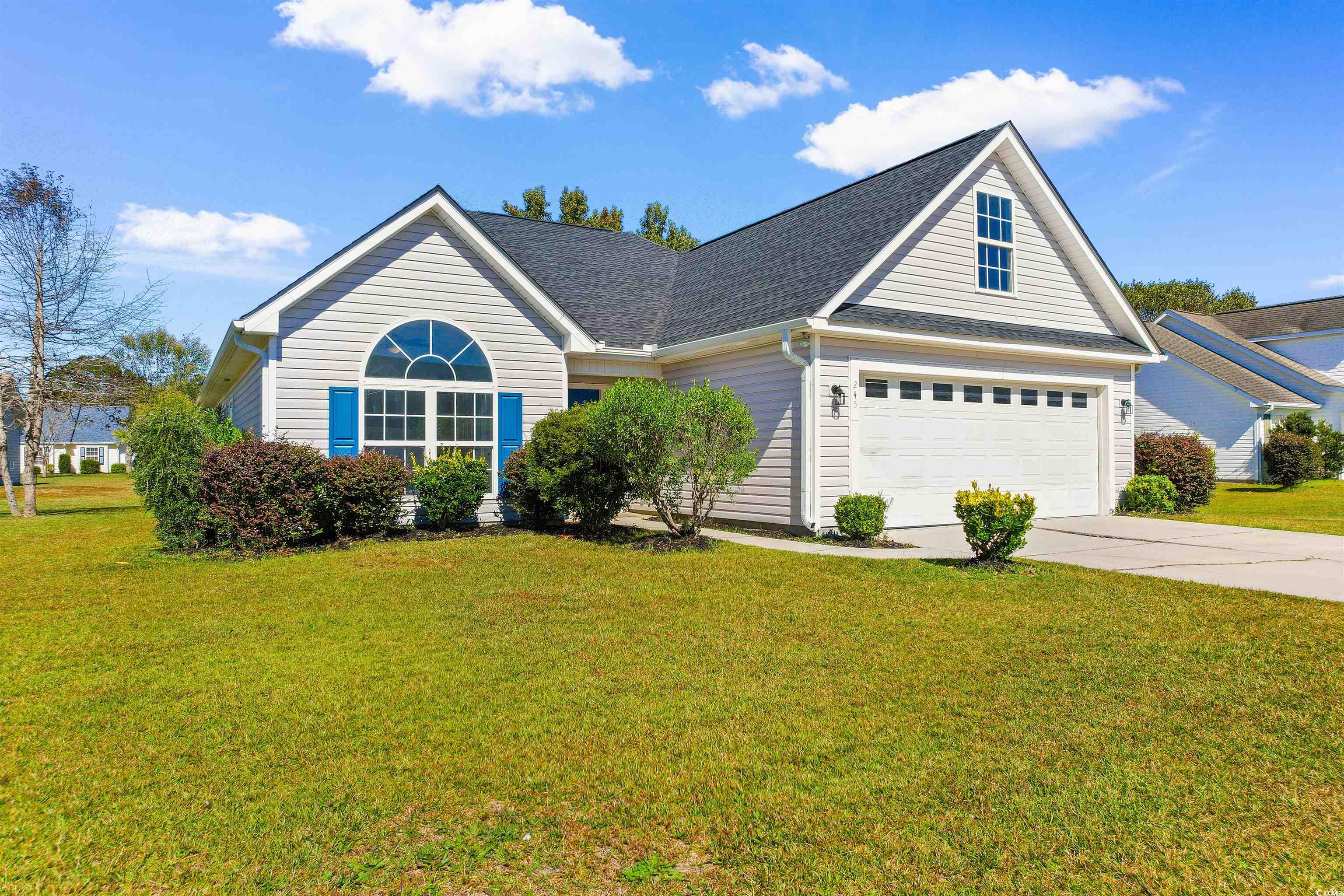 View of front of home with a front yard and a gara