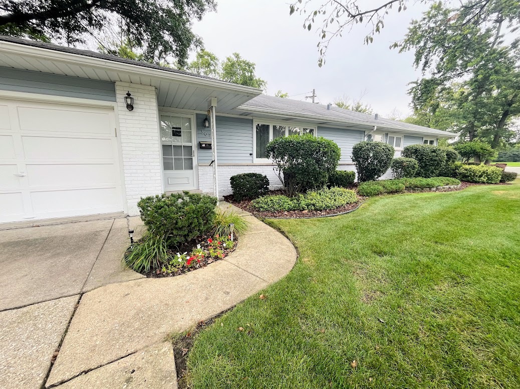 a view of a house with a yard and potted plants